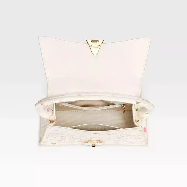 A stylish half-moon shaped genuine leather handbag with a decorative lock, showcasing premium British craftsmanship and timeless elegance.