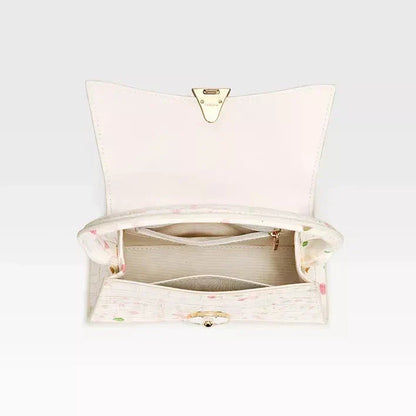A stylish half-moon shaped genuine leather handbag with a decorative lock, showcasing premium British craftsmanship and timeless elegance.