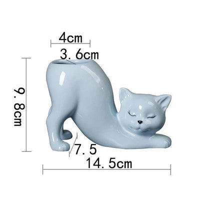 A white ceramic flower pot with a playful cartoon cat design and a functional tail element, perfect for desktops and small spaces.