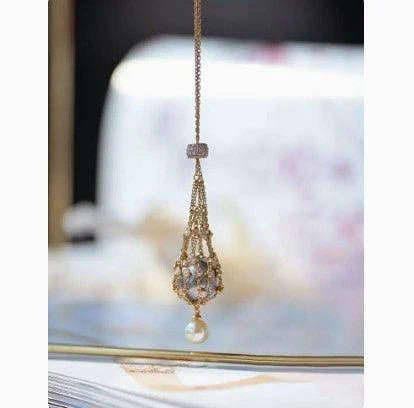 Exquisite 18K gold necklace with a delicate net pocket, inlaid gem, and iridescent shell beads