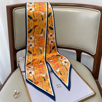 A vibrant floral-patterned silk-feel long scarf that can be worn as a neck accessory, hair tie, or wrist adornment for all occasions.