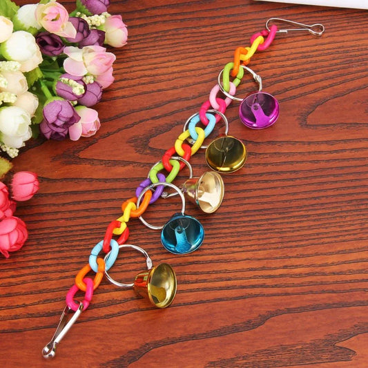 Acrylic bird bells swing with intricate design, hanging in a lush garden setting