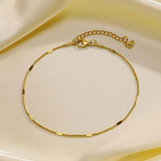 Elegant gold stainless steel minimalist anklet with delicate charm, adjustable length, and durable construction