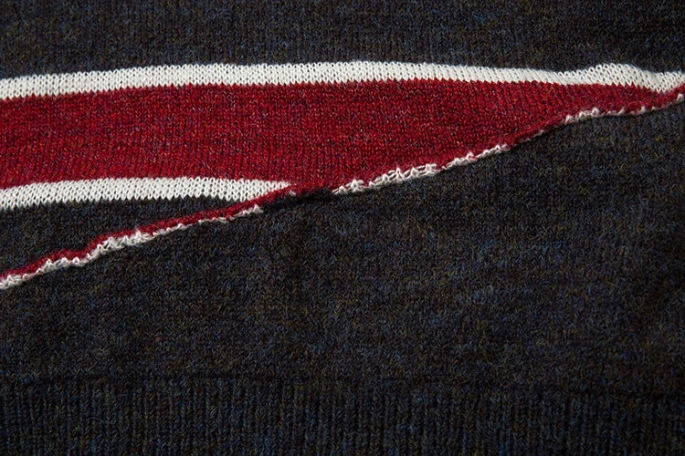A cosy and stylish jumper featuring a patchwork design with contrasting stripes in a classic British colour palette.