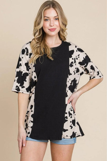Stylish ribbed tee with playful cow print design, perfect for casual and smart-casual occasions.