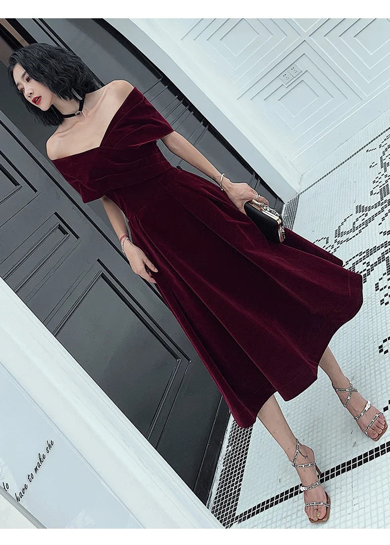 Off-shoulder wine red bridal dress with long, flowing skirt and tight waist for a sophisticated, elegant look