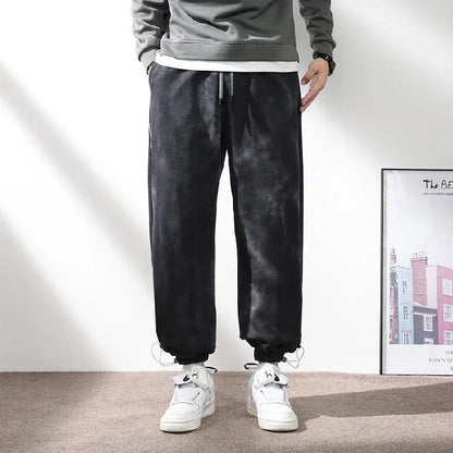 Stylish ankle-tied sweatpants in camouflage black, featuring an elasticated waistband, drawstring, and ankle ties for a relaxed yet refined look.