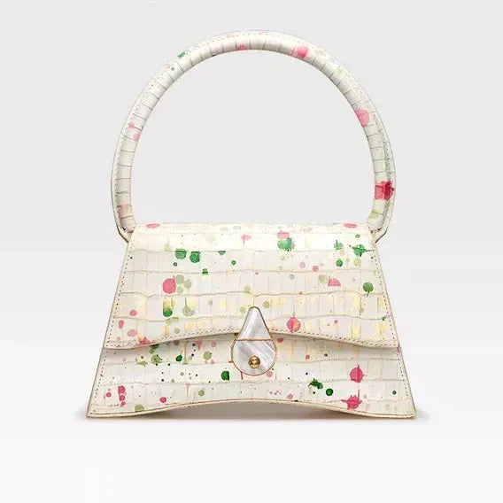 A stylish half-moon shaped genuine leather handbag with a decorative lock, showcasing premium British craftsmanship and timeless elegance.