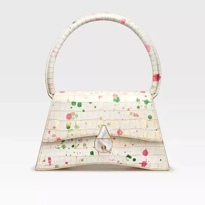 A stylish half-moon shaped genuine leather handbag with a decorative lock, showcasing premium British craftsmanship and timeless elegance.