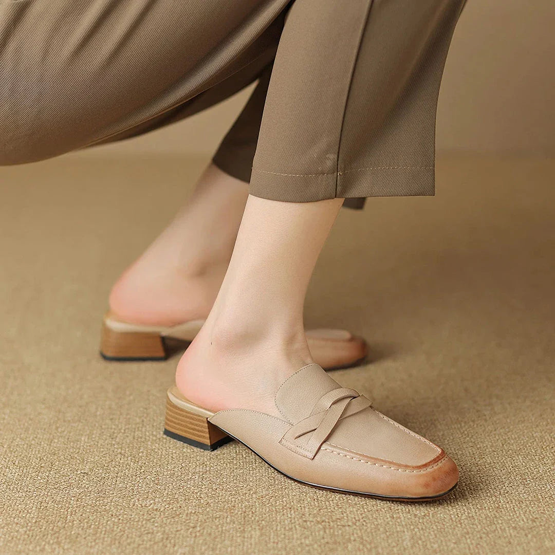 Stylish leather mules in a khaki colour, featuring a low square heel and a sleek, shallow-cut design for a retro-inspired, sophisticated look.