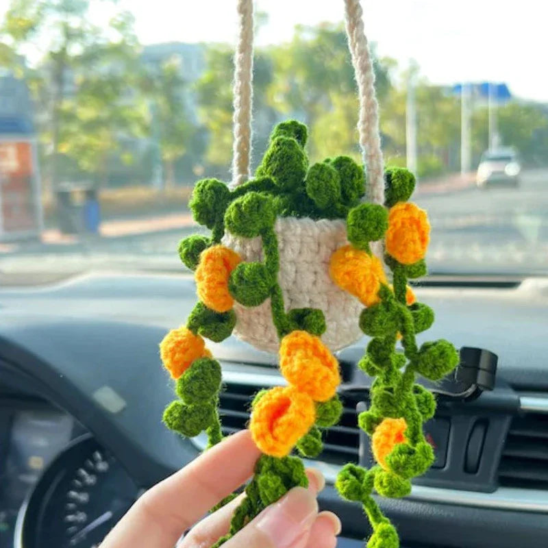 Charming knitted car plant decor with hanging white rope and green and white colour scheme