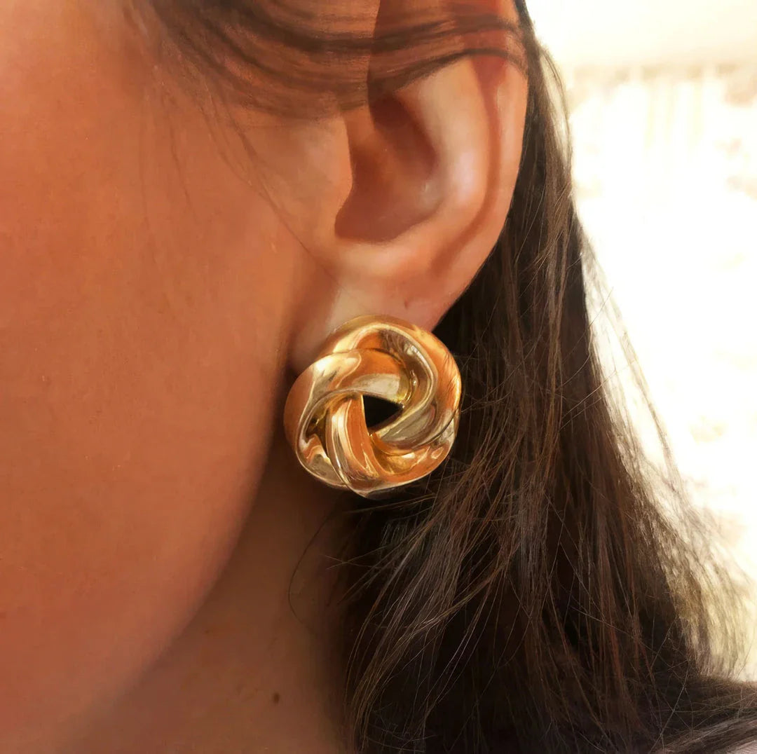 Pair of gold spiral drop earrings with an exaggerated, dramatic design for a bold, fashionable look