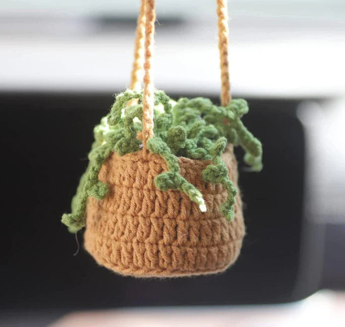 Charming knitted car plant decor with hanging white rope and green and white colour scheme