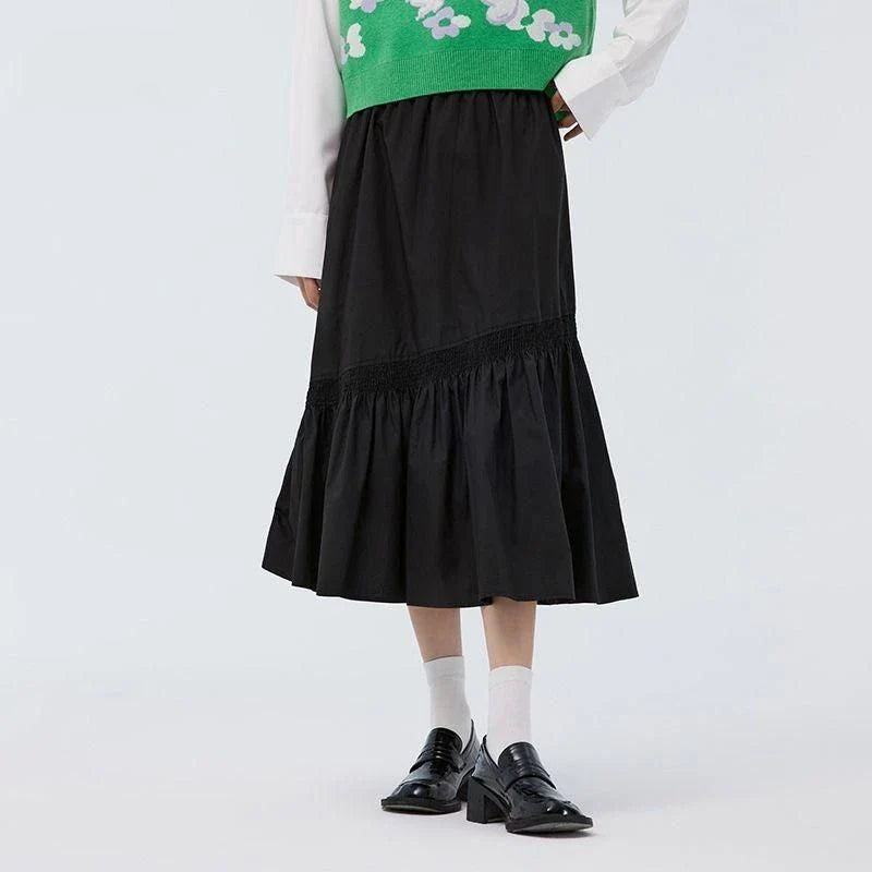 Elegant mid-length black skirt with an A-line silhouette, natural waistline, and unique irregular hemline, perfect for the modern British woman's wardrobe