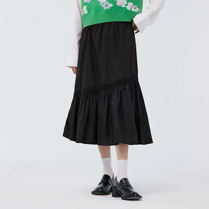 Elegant mid-length black skirt with an A-line silhouette, natural waistline, and unique irregular hemline, perfect for the modern British woman's wardrobe