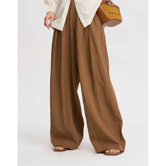 Pleated wide-leg high-waisted trousers in a herringbone plaid pattern, featuring a flattering silhouette and comfortable cotton-linen blend