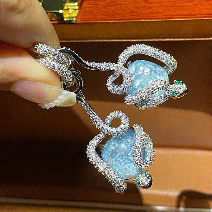 Sophisticated snake-inspired luxury earrings in a copper finish with inlaid gems and semi-precious stones