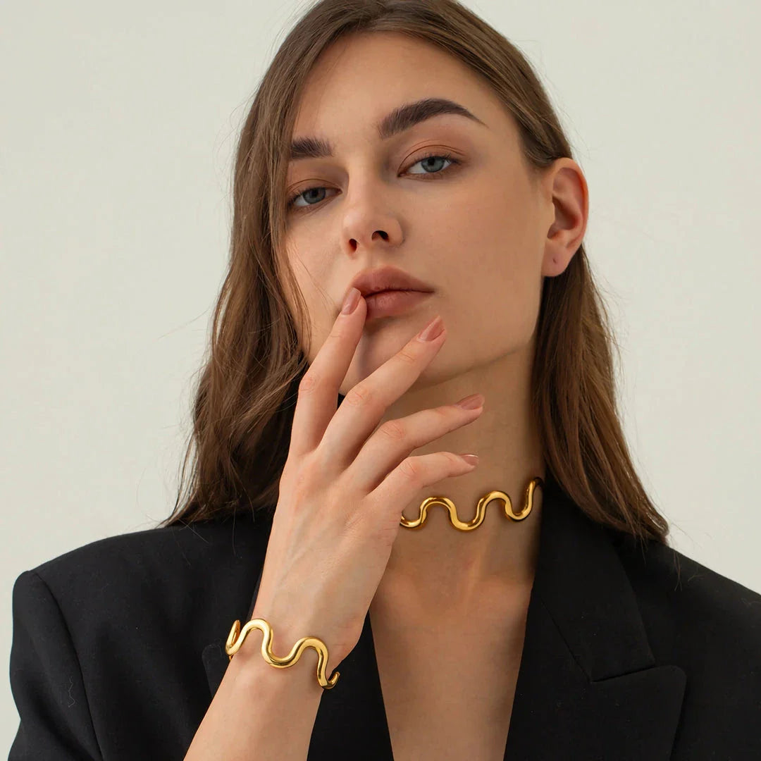 Elegant 18K gold-plated stainless steel wave bracelet and necklace set for women, showcasing a unique contemporary design with adjustable drawstring closure