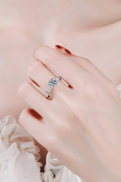 Closeup of an elegant sterling silver ring with a sparkling moissanite centre stone in a 6-prong setting