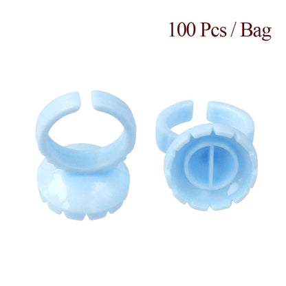 Heart-shaped disposable eyelash glue rings in blue, pink, and white colours