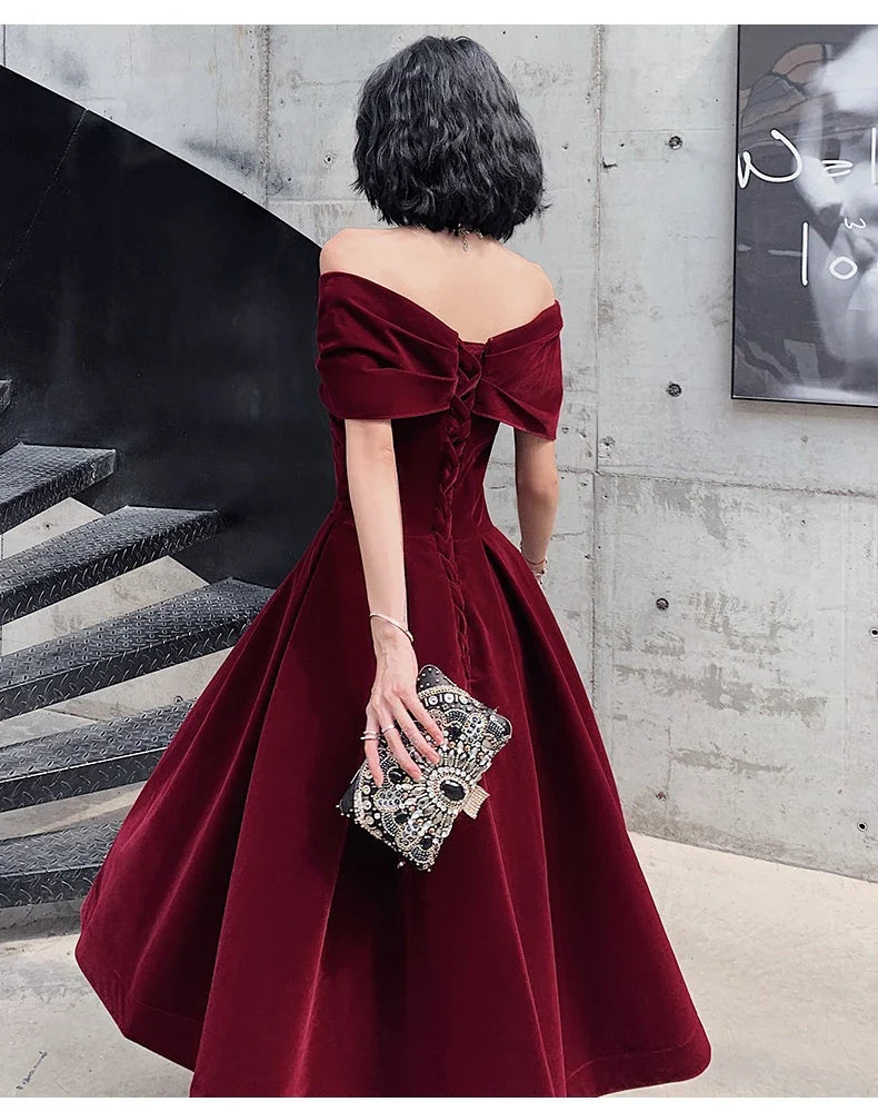 Off-shoulder wine red bridal dress with long, flowing skirt and tight waist for a sophisticated, elegant look
