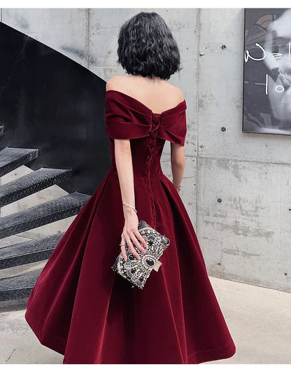 Off-shoulder wine red bridal dress with long, flowing skirt and tight waist for a sophisticated, elegant look