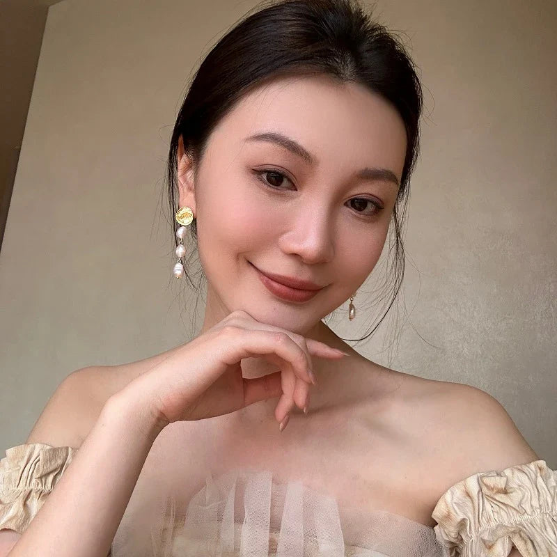 Elegant pearl and gold plated earrings with a long, eye-catching design