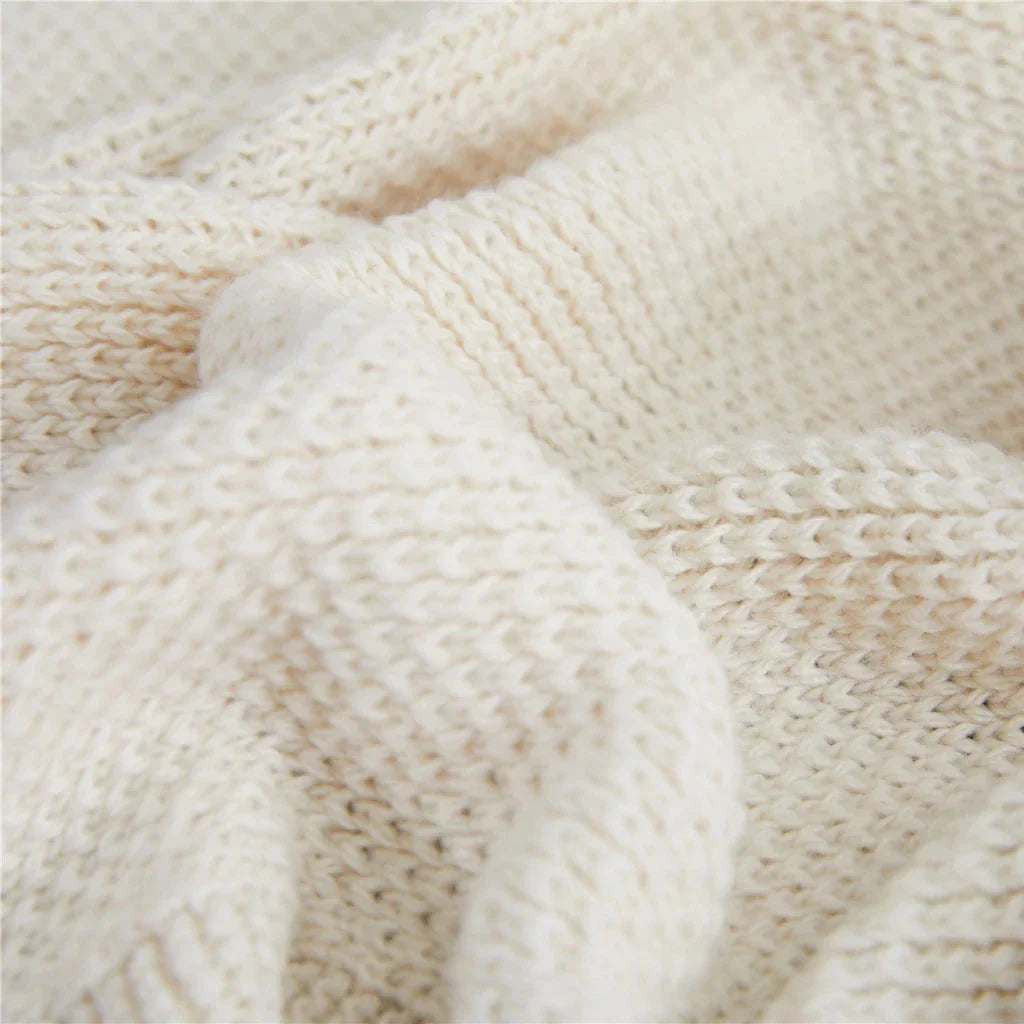 Luxurious Nordic-style wool knitted throw blanket in grey colour, featuring a solid pattern and elegant tassel design