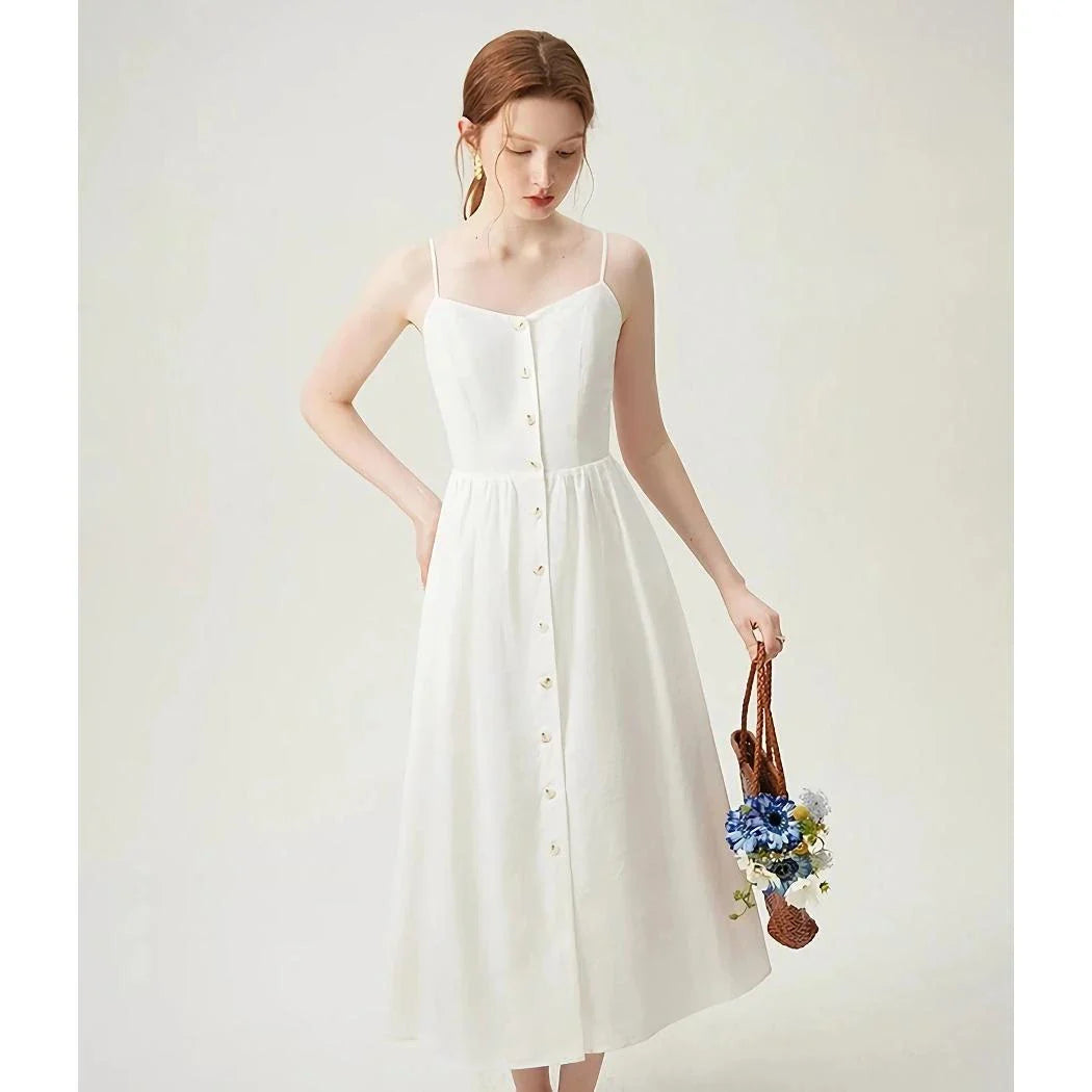Elegant cotton and linen suspender dress with square collar neckline, A-line silhouette, and mid-calf length for a sophisticated and comfortable summer look.
