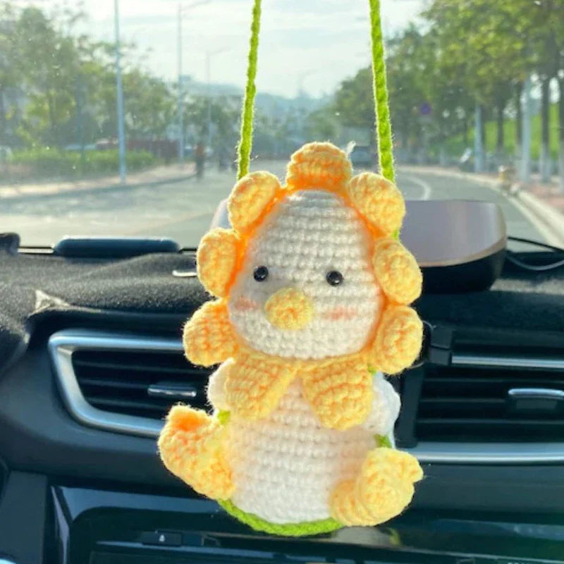 Charming knitted car plant decor with hanging white rope and green and white colour scheme
