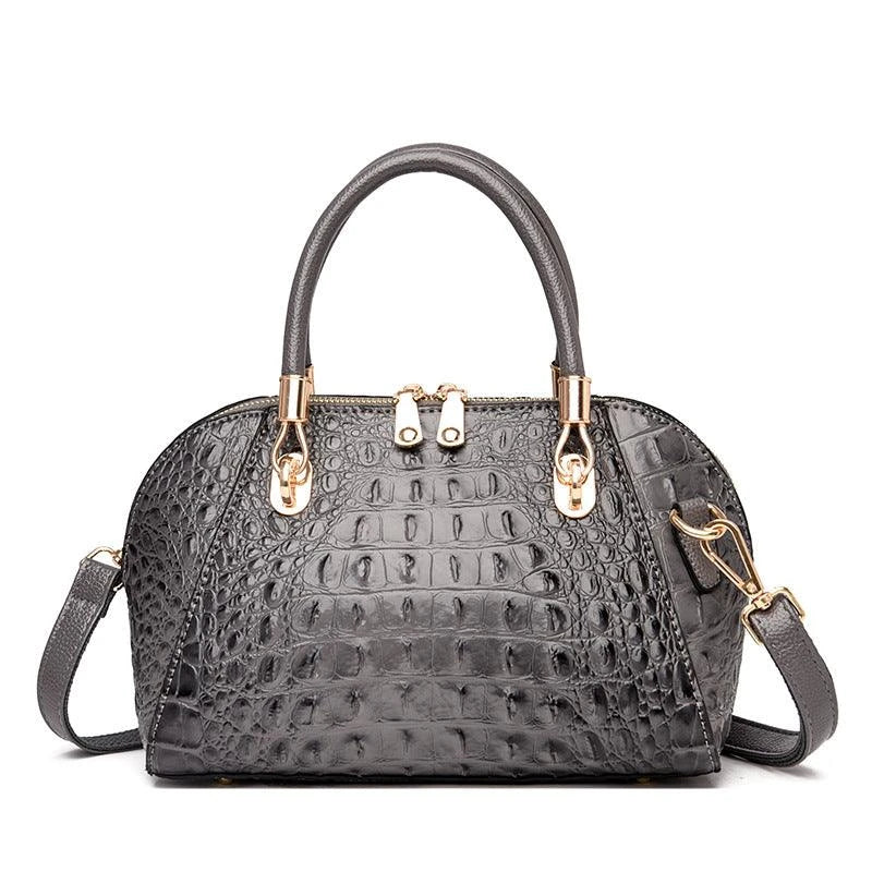Premium leather one-shoulder messenger bag in various colours, featuring a sleek, shell-inspired silhouette and multiple internal pockets for organisation.