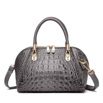 Premium leather one-shoulder messenger bag in various colours, featuring a sleek, shell-inspired silhouette and multiple internal pockets for organisation.