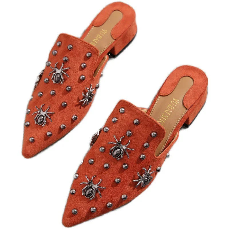 A pair of flat-bottomed, lazy half-slipper style sandals in a sleek, minimalist design with metal accents
