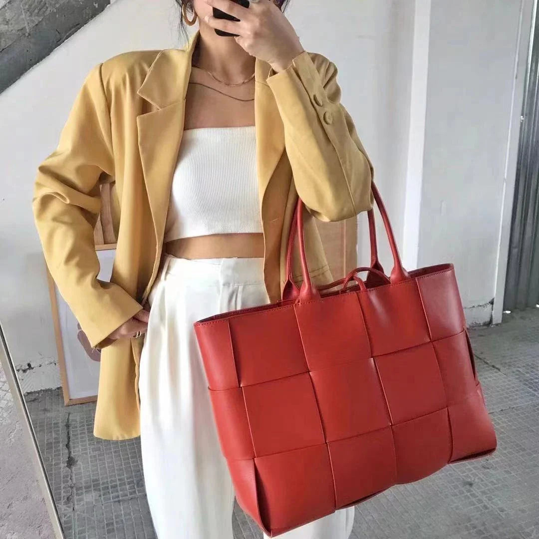 Exquisitely crafted leather tote bag with a timeless woven design, embodying British elegance and quality.
