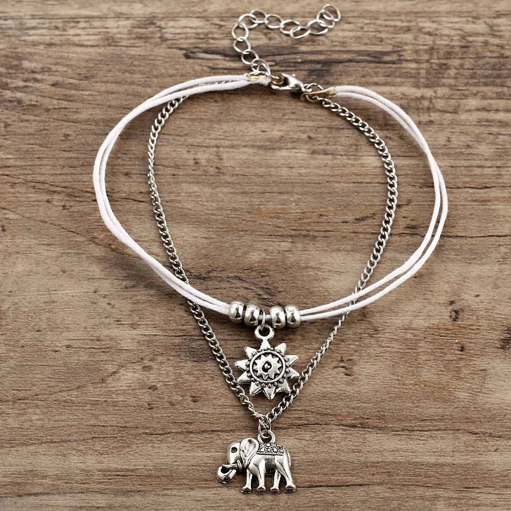 Elegant bohemian-style anklet with star and elephant charms in shimmering gold and silver tones