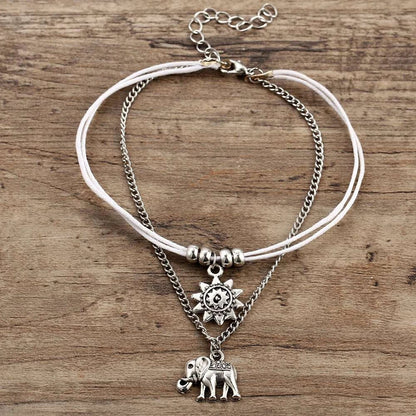Elegant bohemian-style anklet with star and elephant charms in shimmering gold and silver tones