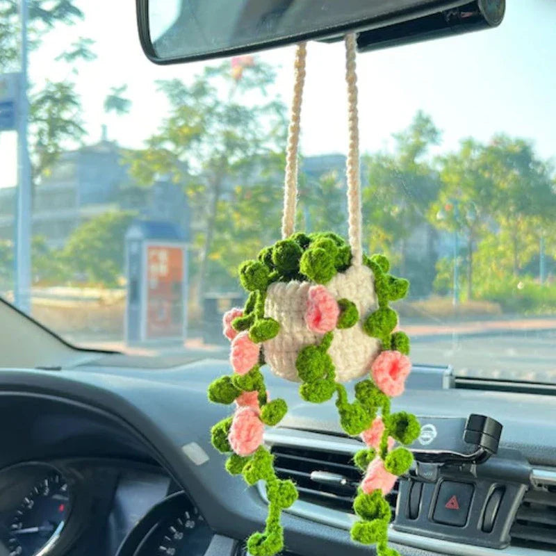 Charming knitted car plant decor with hanging white rope and green and white colour scheme