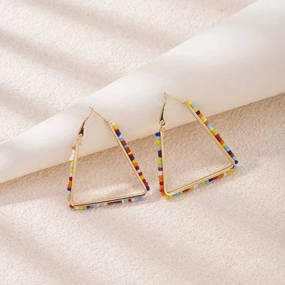 Colourful beaded triangle hoop earrings in gold metal with vibrant beadwork