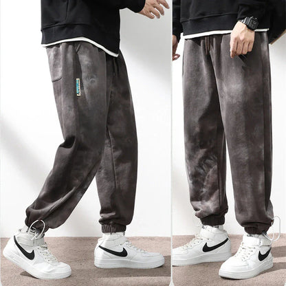 Stylish ankle-tied sweatpants in camouflage black, featuring an elasticated waistband, drawstring, and ankle ties for a relaxed yet refined look.