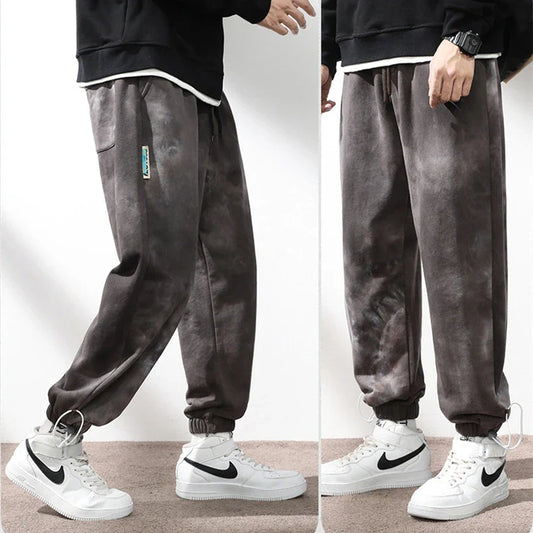 Stylish ankle-tied sweatpants in camouflage black, featuring an elasticated waistband, drawstring, and ankle ties for a relaxed yet refined look.
