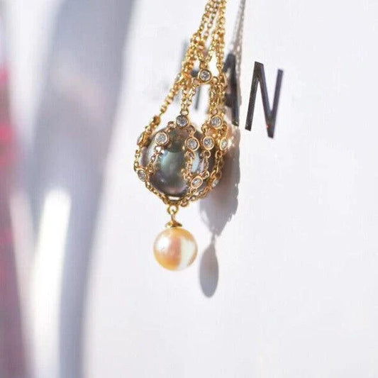 Exquisite 18K gold necklace with a delicate net pocket, inlaid gem, and iridescent shell beads