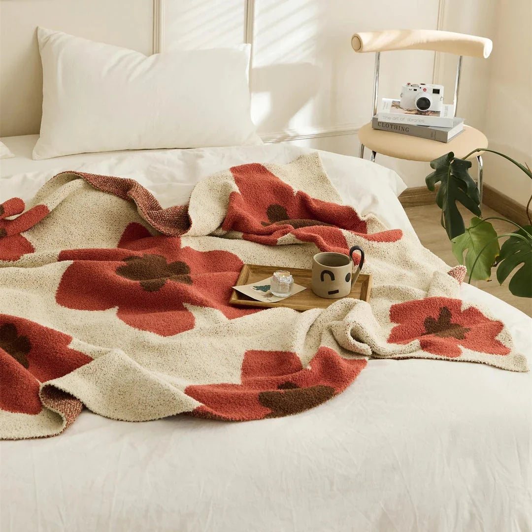 Cosy floral knitted throw blanket in red, featuring a chic bohemian design and luxurious microfibre fabric for maximum comfort and style.