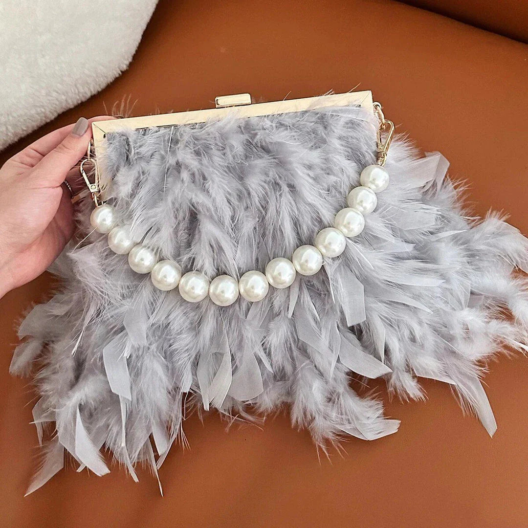 Elegant feather clutch purse with lustrous pearls, metal chains, and a top handle design