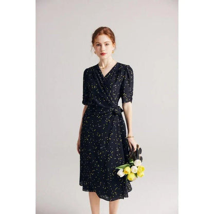 Sophisticated black polka dot silk wrap dress with a flattering V-neck and empire waistline, suitable for various occasions.