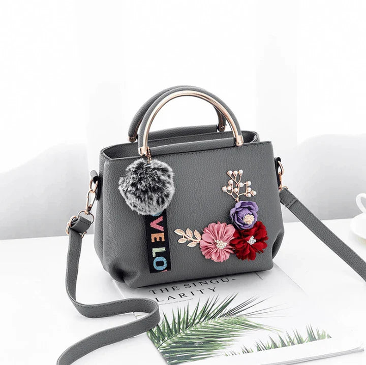Elegant leather tote bag with delicate flower embellishments, perfect for modern British fashion