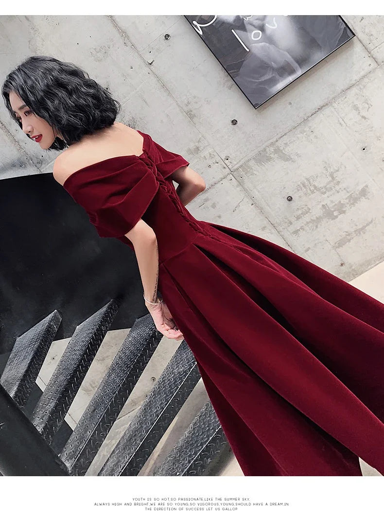 Off-shoulder wine red bridal dress with long, flowing skirt and tight waist for a sophisticated, elegant look