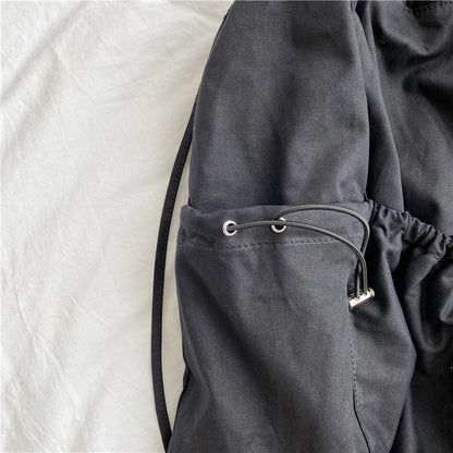 A stylish drawstring bucket bag in white, black, or brown colour options, featuring a spacious interior and adjustable closure for modern British women.