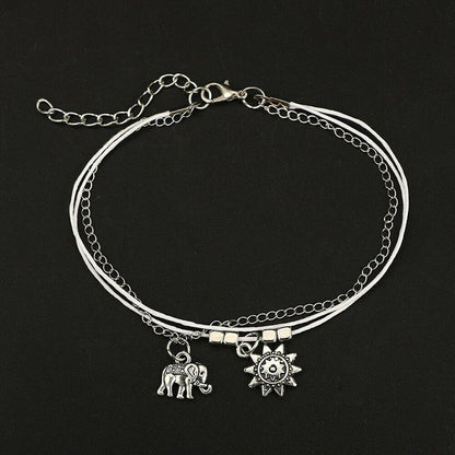 Elegant bohemian-style anklet with star and elephant charms in shimmering gold and silver tones