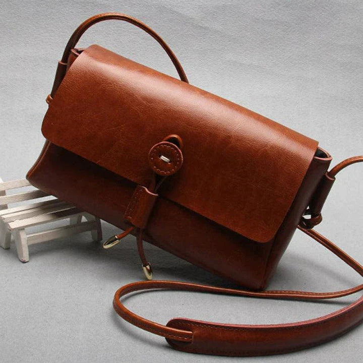 Premium leather crossbody bag in a sleek, horizontal square design with subtle car stitching details