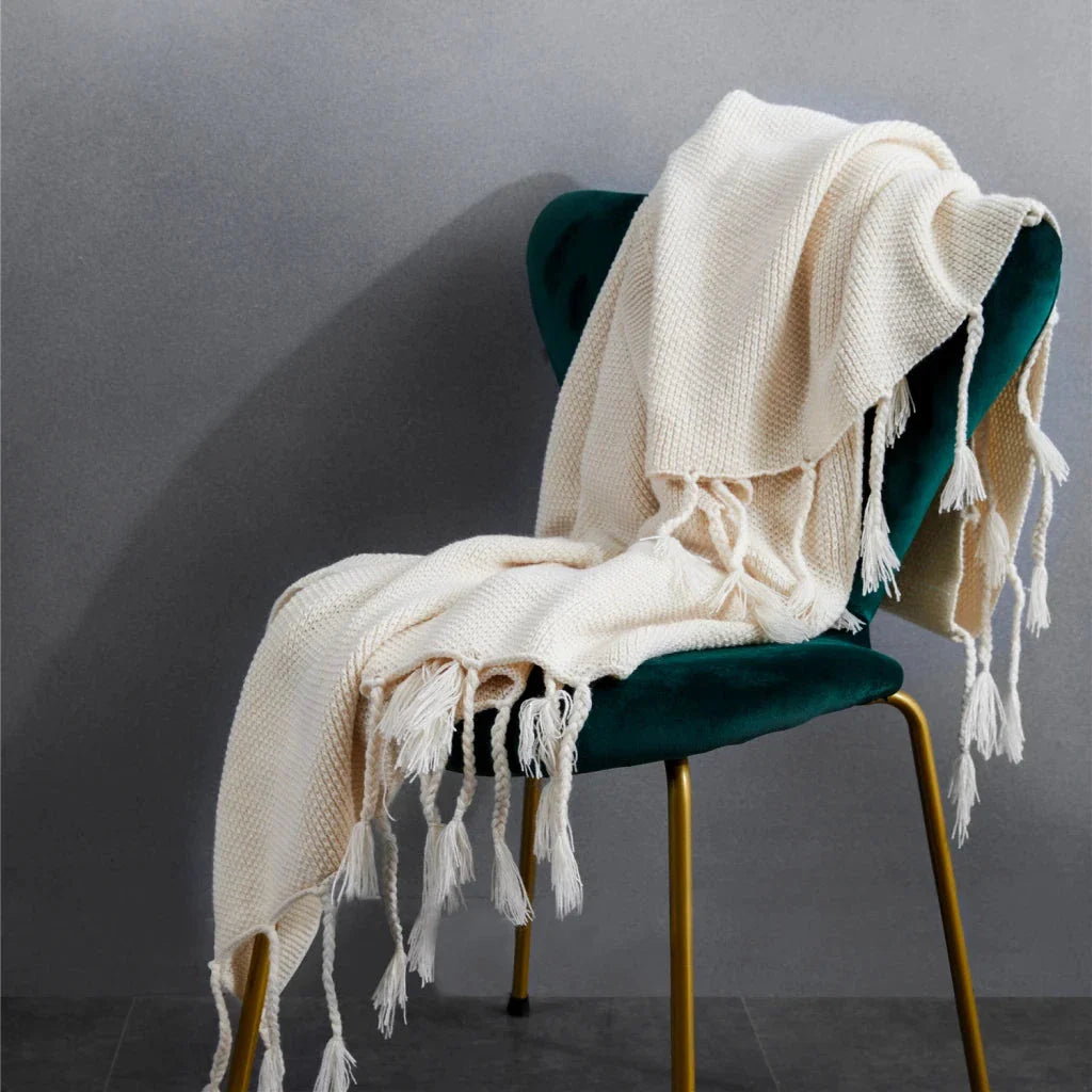 Luxurious Nordic-style wool knitted throw blanket in grey colour, featuring a solid pattern and elegant tassel design